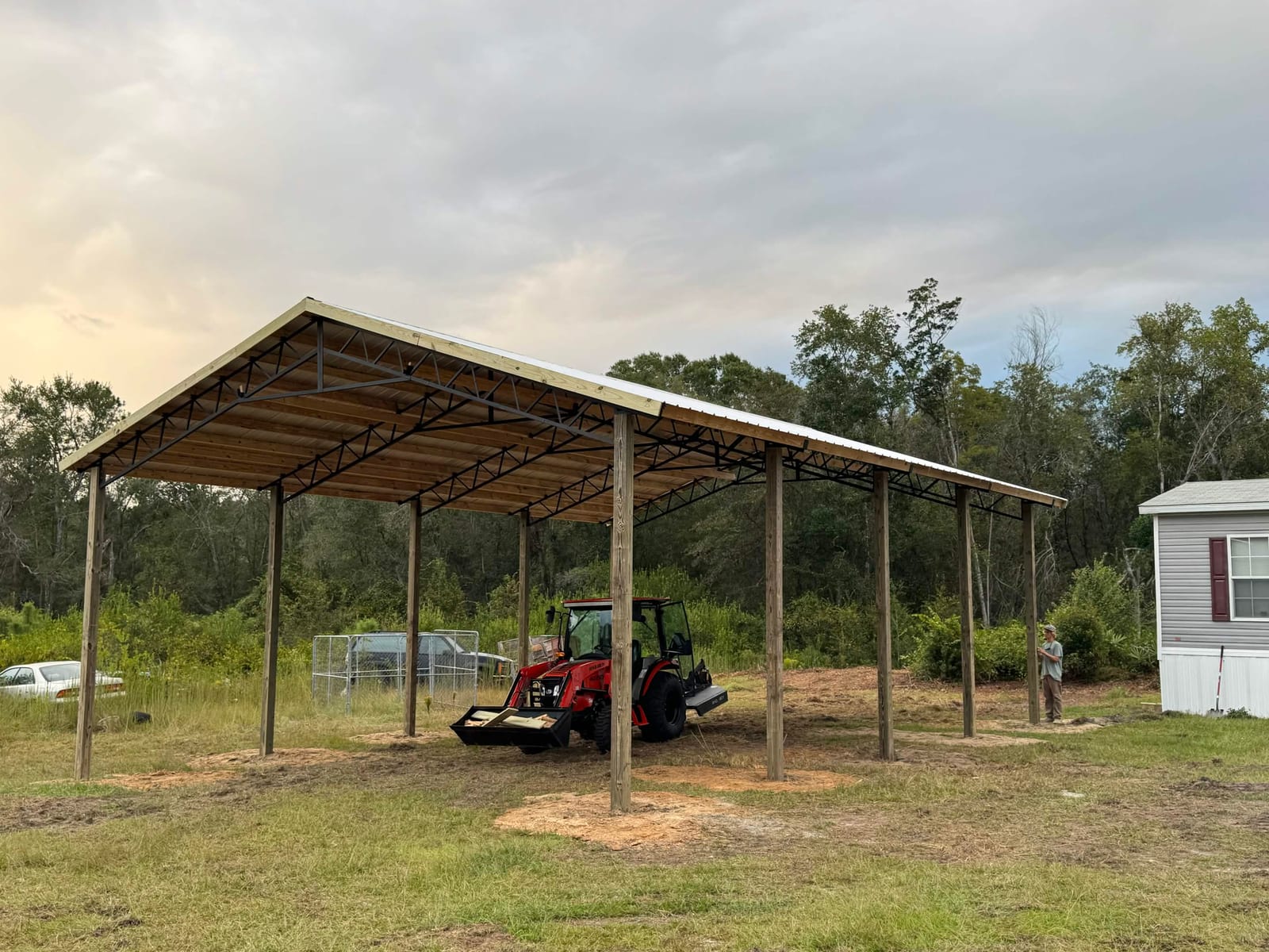 Open-sided pole barn with tractor parked underneath
