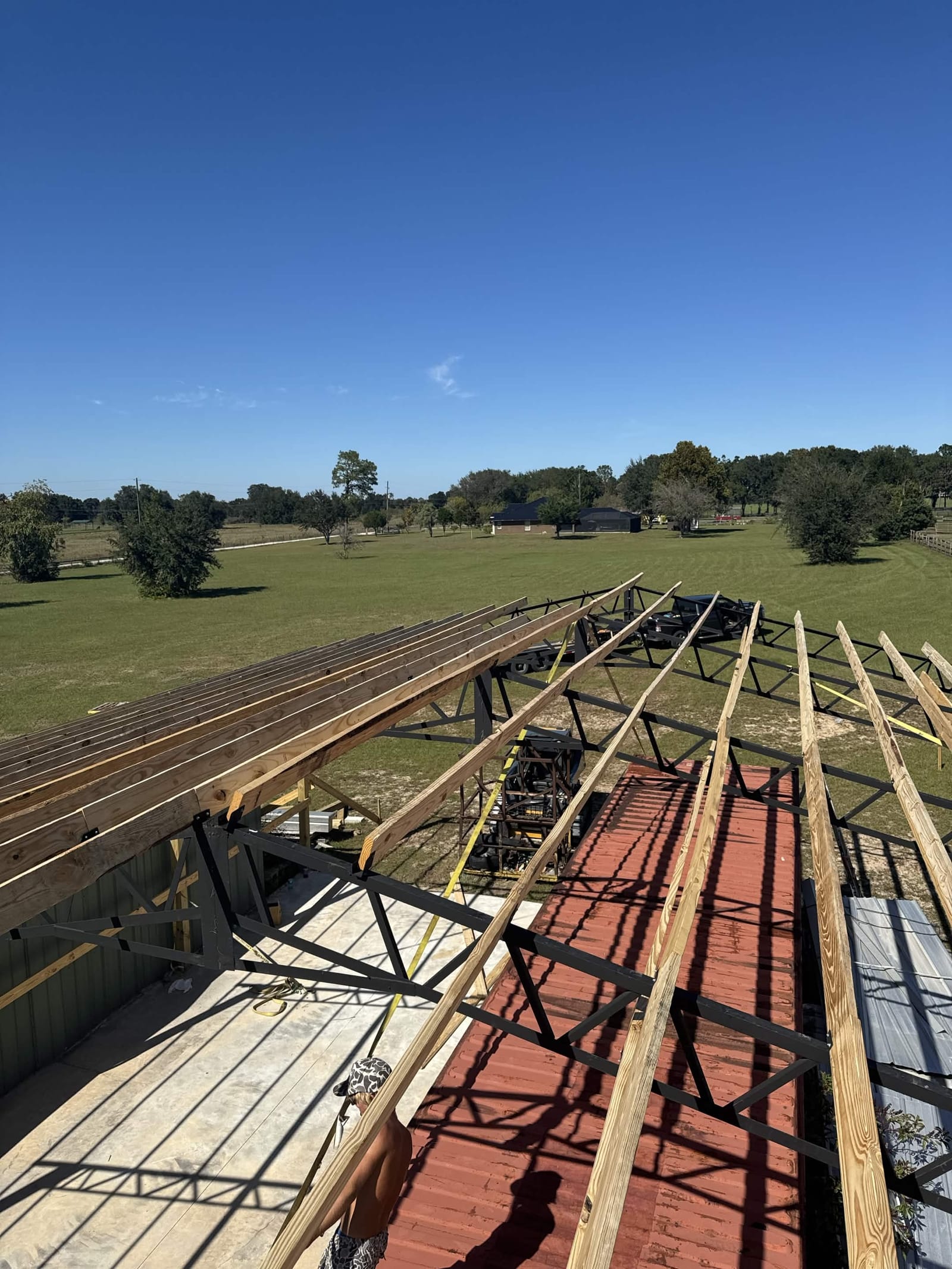 Roof truss framing during construction with green pasture below